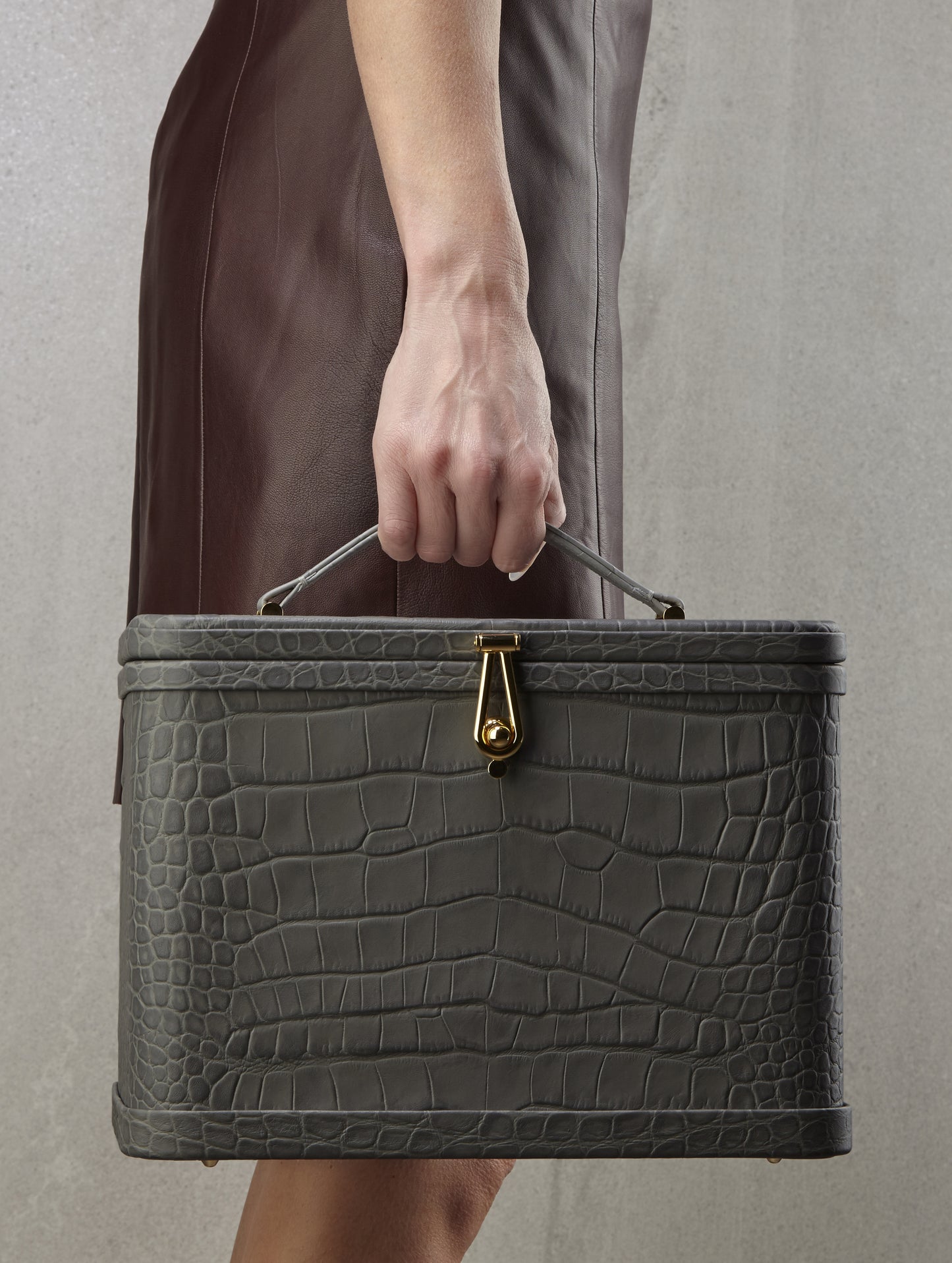 Atelier Verdi large grey crocodile print leather vanity case held by model