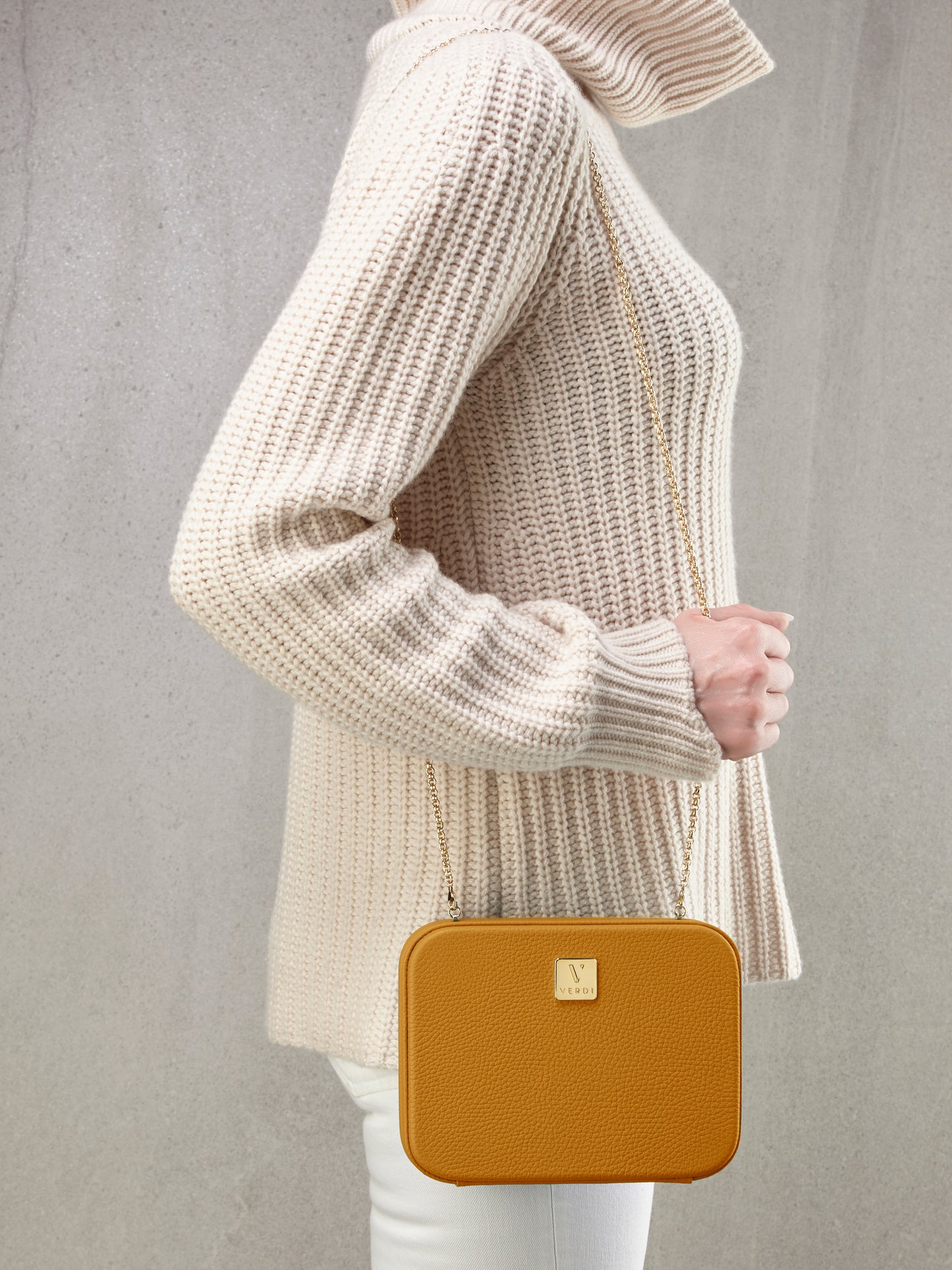Atelier Verdi yellow leather clutch bag worn over the shoulder by model