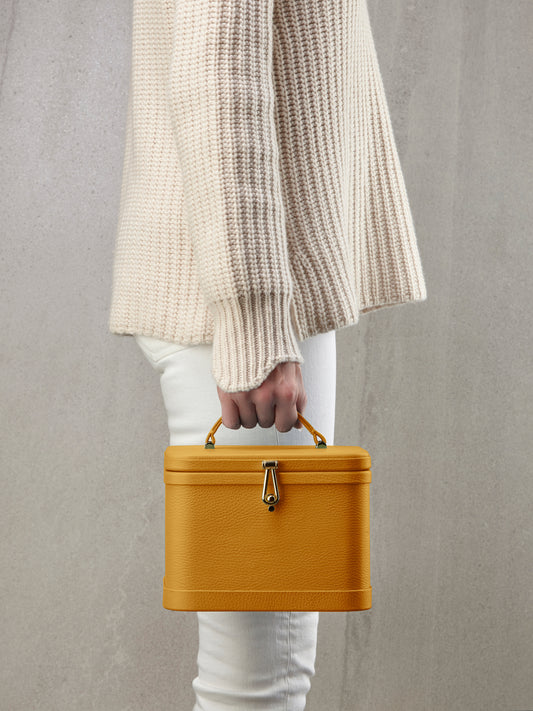 Atelier Verdi small yellow leather vanity case held by model