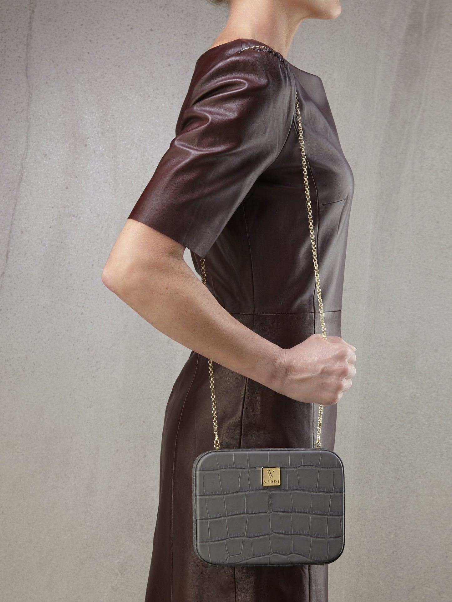 Atelier Verdi grey crocodile print leather clutch bag worn over the shoulder by model