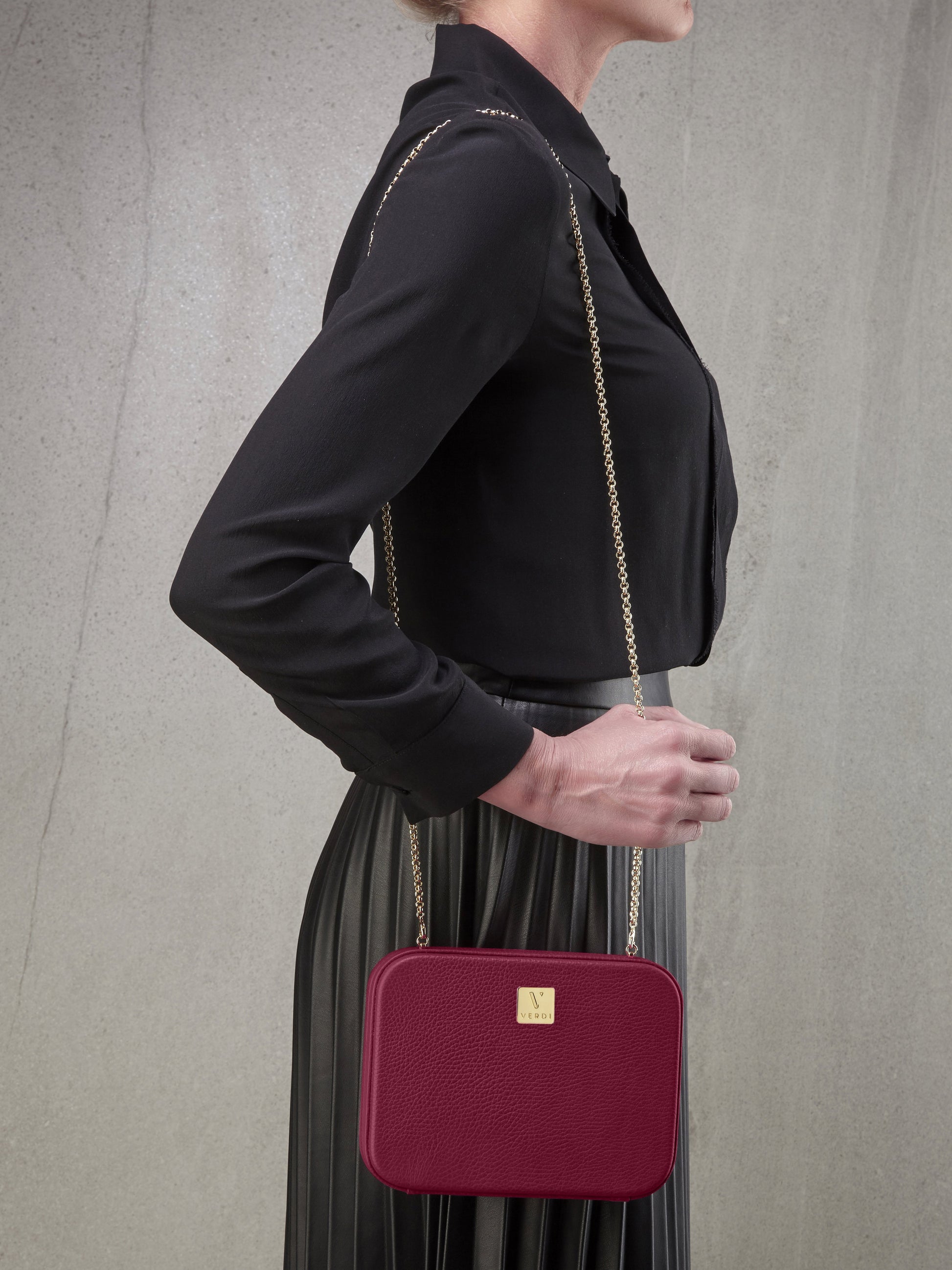 Atelier Verdi pink leather clutch bag worn over the shoulder by model